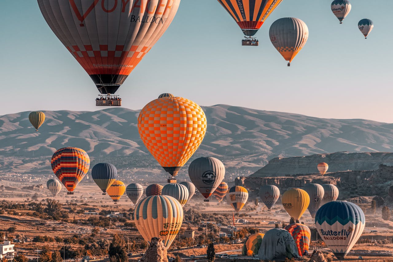 gallery-2 Colorful hot air balloons soaring over Cappadocia's unique landscape in Türkiye.