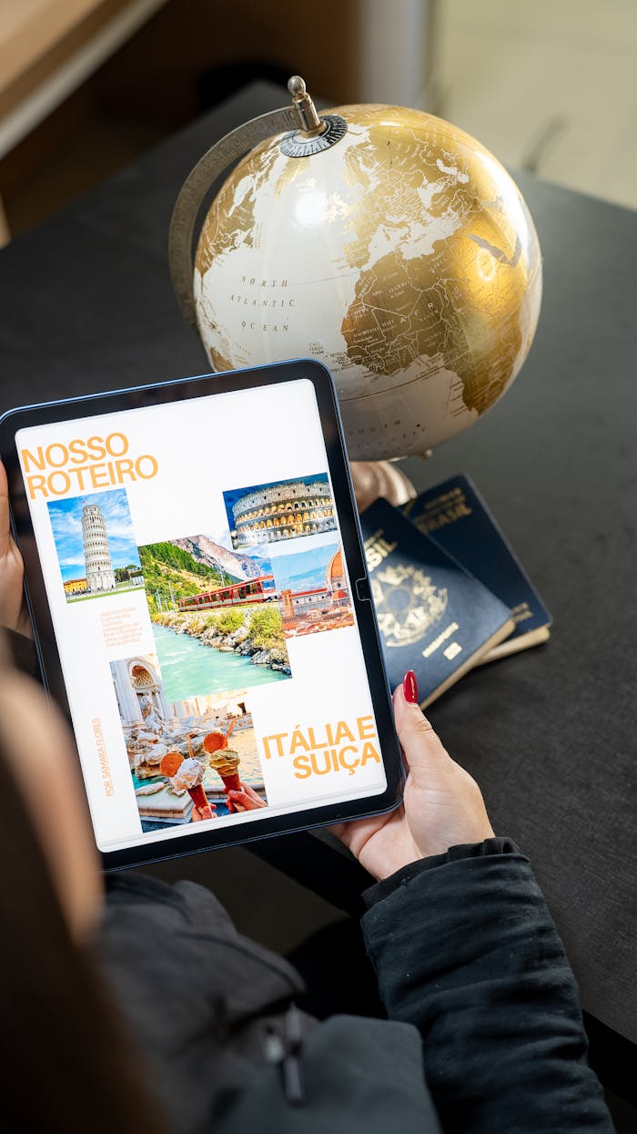 gallery-4 Traveler planning a trip to Italy and Switzerland using a globe, tablet, and passports.