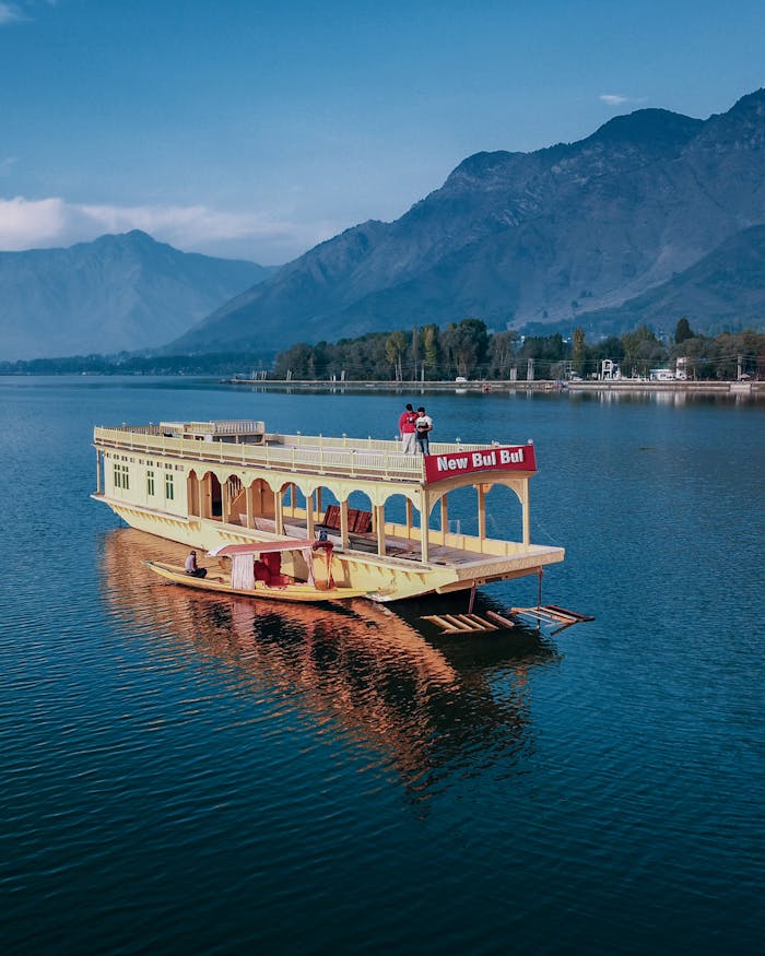 gallery-5 A vibrant houseboat on Dal Lake with stunning mountain backdrop, perfect for travel and leisure.
