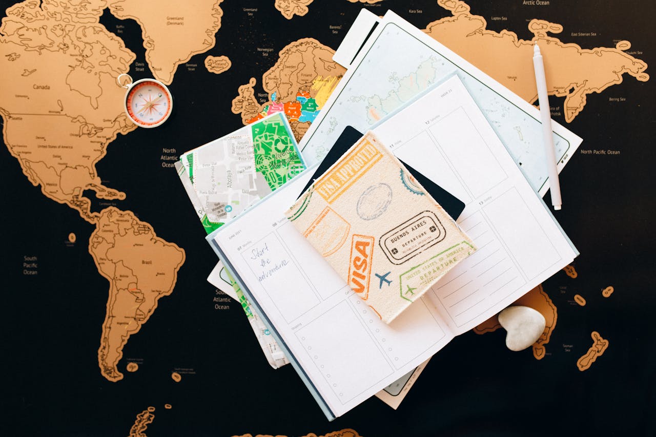 gallery-3 A flat lay of travel planning items on a map, featuring a compass, notebook, and guide for wanderlust enthusiasts.