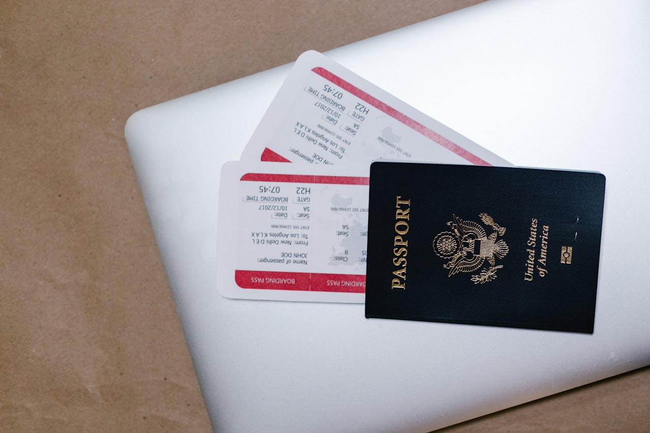 services-02 Close-up of a passport and boarding passes on a laptop, symbolizing travel preparation.
